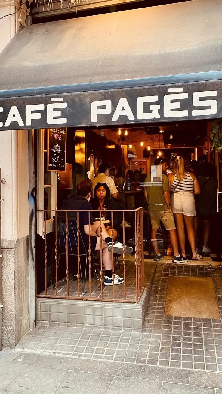 La entrada de Cafè Pagès de noche, llena de gente